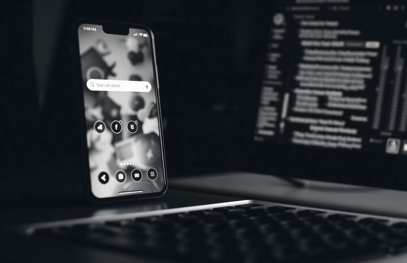 Teléfono móvil con un buscador junto a una pantalla de ordenador en blanco y negro